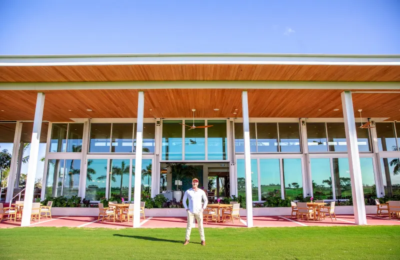 Connor Walsh on the lawn in front of the Atlantic Fields Golf House window wall