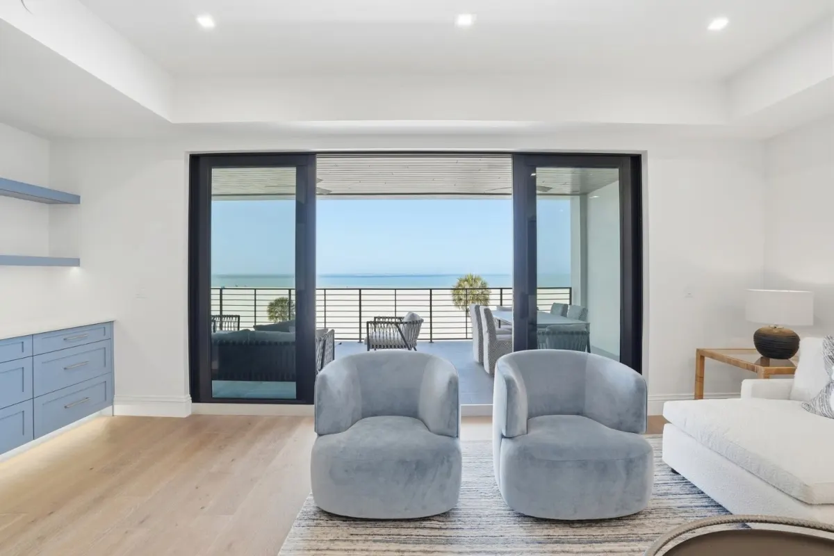 A living room opening to a balcony over the Gulf through sliding glass doors
